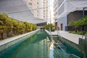 a pool of green water in the middle of a building at My Place in Curitiba