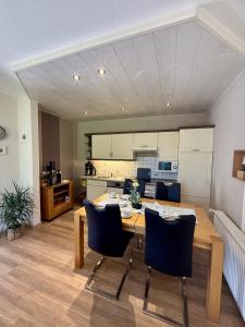 eine Küche und ein Esszimmer mit einem Holztisch und Stühlen in der Unterkunft Ferienhaus Blinkfuer in Neuharlingersiel
