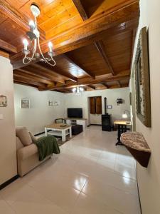 ein Wohnzimmer mit Holzdecken und einem Sofa in der Unterkunft O Lar do Bispo by CABANA Rentals in Arbo