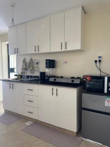 a kitchen with white cabinets and a microwave at Lakeview Apartments - The Nest in Mbita