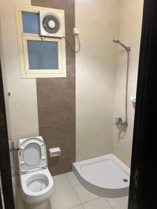 a small bathroom with a toilet and a window at شقق نازلين للشقق المخدومة in Al Bahadah