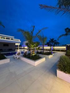 RrushkullInfinity Villa的夜间带游泳池和棕榈树的度假村