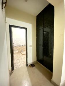 un bagno con una grande doccia nera e una porta di Suites Inn a Faisalabad