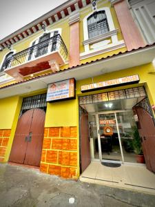 un edificio giallo con pizzeria di Travel Comfort Quito Tourist Hostel a Quito