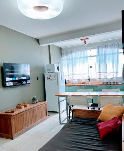 une pièce avec une cuisine avec une table et un réfrigérateur dans l'établissement Apartamento Studio 203, à Juazeiro