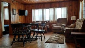 un salon avec une table et des chaises dans l'établissement Rustic Cabin on the Shores of Pine Lake, Michigan, à Wellston 6 autres photos