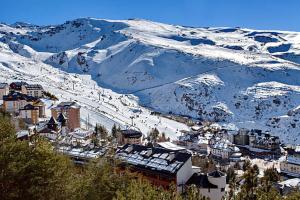 eine Stadt mit schneebedeckten Bergen im Hintergrund in der Unterkunft Rincón de Sierra Nevada in Cenes de la Vega