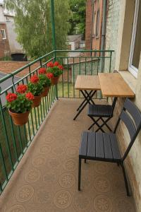 a balcony with a table and two benches and flowers at TANIE NOCLEGOWANIE in Katowice