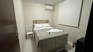 een kleine slaapkamer met een bed en een stoel bij Cores De Outono Suítes in Canela