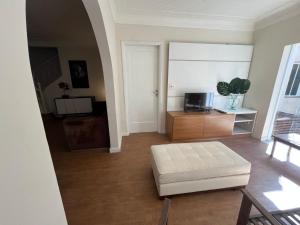 a living room with a white couch and a tv at Palais House in São Vicente
