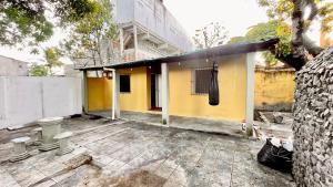 a small yellow house with a building at El Gringo in Cabo de Santo Agostinho +3 photos