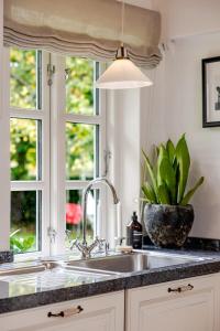 a kitchen sink with a potted plant next to a window at Thatched country escape - Aarhus in Lystrup +21 photos