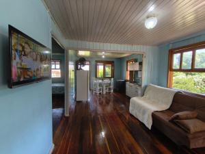 a living room with a couch and a kitchen at Casa de vó do interior, cidade do Cristo Protetor in Encantado