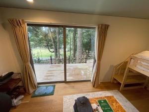 Cette chambre dispose d'une grande porte coulissante en verre avec une terrasse. dans l'établissement Aiueo no Mori - Vacation STAY 79153v, à Yamashiro
