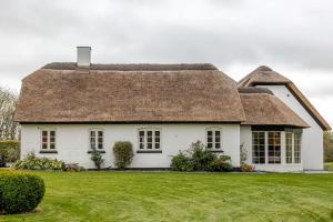 a white house with a thatched roof at Thatched country escape - Aarhus in Lystrup