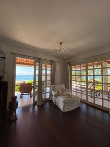 ein Wohnzimmer mit einem Bett und Meerblick in der Unterkunft Pousada Chic N Choc in Morro de São Paulo