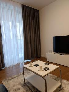 a living room with a coffee table and a flat screen tv at Planet Green Residence in Niš