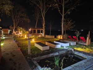 Un jardín iluminado por la noche con un estanque en Wellness Sauna Beauty Farm Midwolda, en Midwolda 13 fotos más