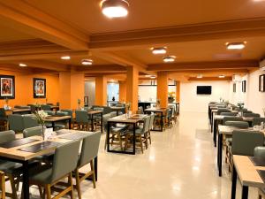 a restaurant with tables and chairs in a room at Le Village Flats e Hotel in Joinville