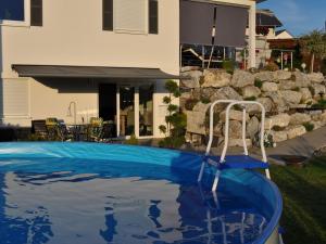 a swimming pool with a slide in front of a house at Wohnung Mit Großer Gartenterrasse Und Ausblick in Argenbühl