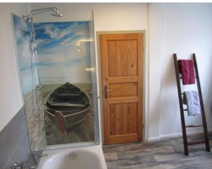 ein Badezimmer mit einem Gemälde eines Bootes neben einer Tür in der Unterkunft Wohnung in Gießelrade mit Großem Garten - b48578 in Ahrensbök