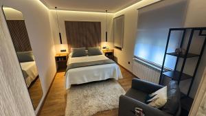 une chambre avec un lit, un miroir et un canapé dans l'établissement La Era Rooms, à Lario