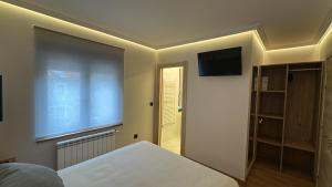 une chambre avec un lit et une télévision à écran plat dans l'établissement La Era Rooms, à Lario 4 autres photos