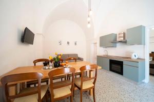 eine Küche und ein Esszimmer mit einem Holztisch und Stühlen in der Unterkunft La Fontana Casaurea Apartment, Centro-AC in Villa Castelli