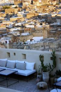 un divano bianco seduto di fronte a un muro di Dar Seffarine a Fes