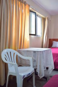 a room with a table and a chair and a window at Hotel La Quinta de Allison in Lima