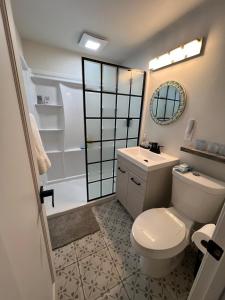 ein Badezimmer mit Toilette, Waschbecken und Spiegel in der Unterkunft Modern Big Bear Cabin With Spa, BBQ & EV Charging on Site in Big Bear City Airport