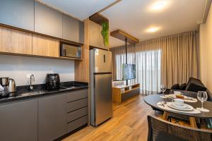 a kitchen and a living room with a table in a room at My Place in Curitiba