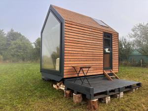 a tiny house sitting on logs in a field at Políčko in České Budějovice
