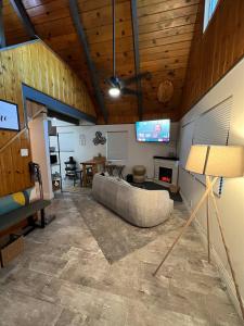 ein Wohnzimmer mit Sofa und Fernseher in der Unterkunft Modern Big Bear Cabin With Spa, BBQ & EV Charging on Site in Big Bear City Airport
