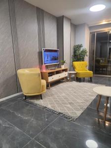 a lobby with two yellow chairs and a television at Penthouse Apartment On The Beach in Bat Yam