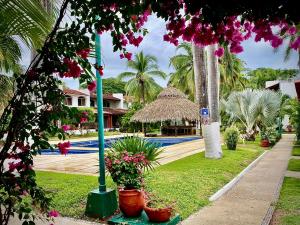 a resort with a pool and some plants and flowers at Casa Romantica De Playa in Ixtapa