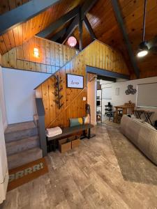 ein Wohnzimmer mit Holzwänden und einem Sofa in der Unterkunft Modern Big Bear Cabin With Spa, BBQ & EV Charging on Site in Big Bear City Airport