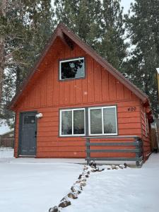 ein rotes Gebäude mit einem Fenster und Schnee auf dem Boden in der Unterkunft Modern Big Bear Cabin With Spa, BBQ & EV Charging on Site in Big Bear City Airport + 23 Fotos