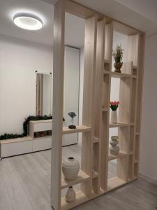 een kamer met een plank met vazen en een spiegel bij President 59 in Craiova