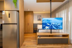 a kitchen with a refrigerator and a television on a table at My Place in Curitiba