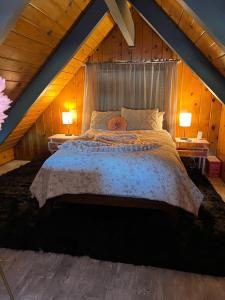 ein Schlafzimmer mit einem großen Bett im Dachgeschoss in der Unterkunft Modern Big Bear Cabin With Spa, BBQ & EV Charging on Site in Big Bear City Airport