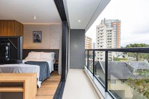 a bedroom with a bed and a balcony at My Place in Curitiba