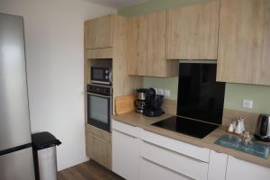 a kitchen with wooden cabinets and a counter top at Chambres tout confort Les Berlingots in Monistrol-sur-Loire