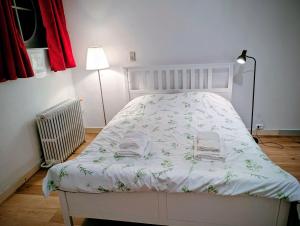 a bedroom with a white bed with a white comforter at Duplex 3BR apartment near supermarkets & metro in Brussels
