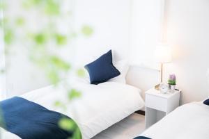 a bedroom with two beds and a white chair at Awaji Riverside Terrace in Shizuki - Vacation STAY 81986v in Shizuki