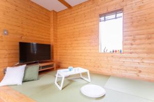 a living room with wooden walls and a flat screen tv at Ａｗａｊｉ Ｓｅａｖｉｅｗ Ｒｅｓｏｒｔ ｉｎ Ｎｏｊｉｍａ - Vacation STAY 81998v in Kusumoto