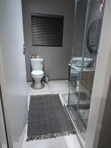 een badkamer met een douche, een toilet en een wastafel bij J & M Elegant escape 2 in Centurion