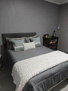 een slaapkamer met een groot bed met kussens bij J & M Elegant escape 2 in Centurion +5 foto's