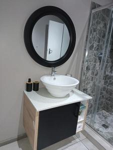 een badkamer met een witte wastafel en een spiegel bij J & M Elegant escape 2 in Centurion