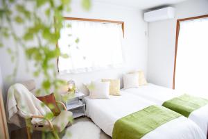 2 Betten in einem Zimmer mit weißen Wänden und Fenstern in der Unterkunft Kuwana - House - Vacation STAY 82016v in Genroku